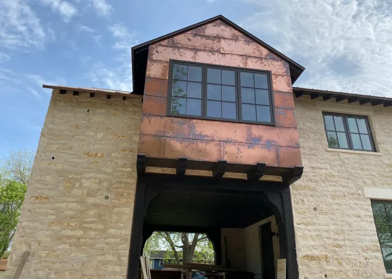 Copper metal panel facade on a stone building for Skylight Installation in Starke